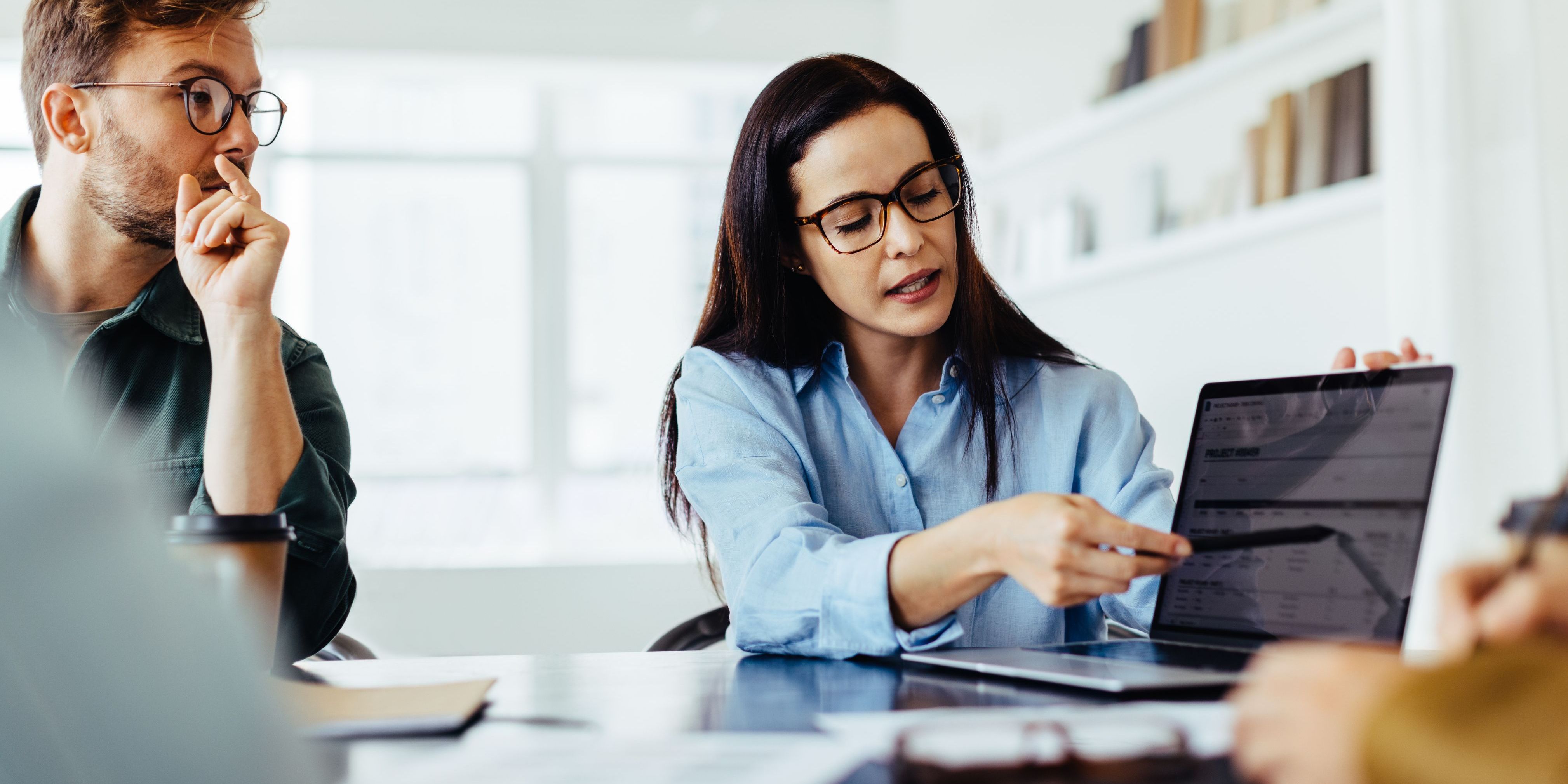 A forensic account examining financial records with a colleague.