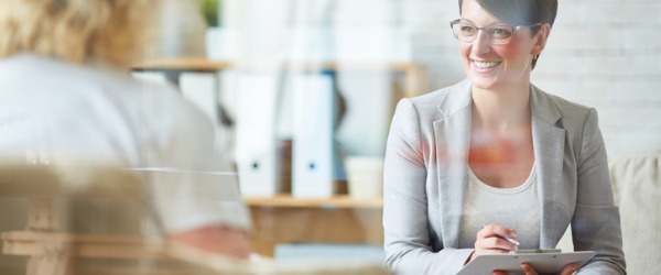 A smiling psychologist sitting across from her client.