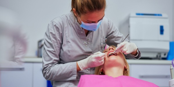 A dental hygienist cleaning a patient's teeth.