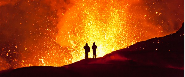 Two volcanologists on the perimeter of a volcano.