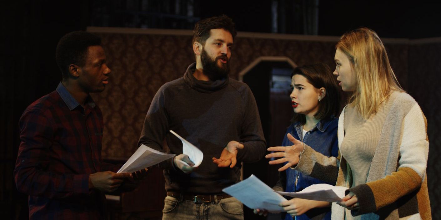 A stage manager talking to actors, and ensuring things are running smoothly.